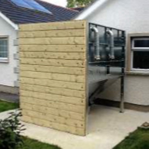 Weather-resistant green-coated steel wood pellet store for outdoor use in Cumbria.